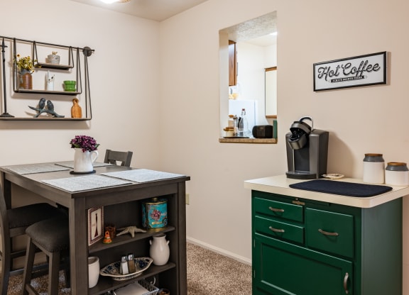 a kitchen with a desk and a green cabinet and a mirror