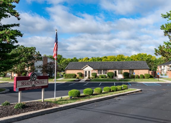 an empty parking lot in front of a house with an flag