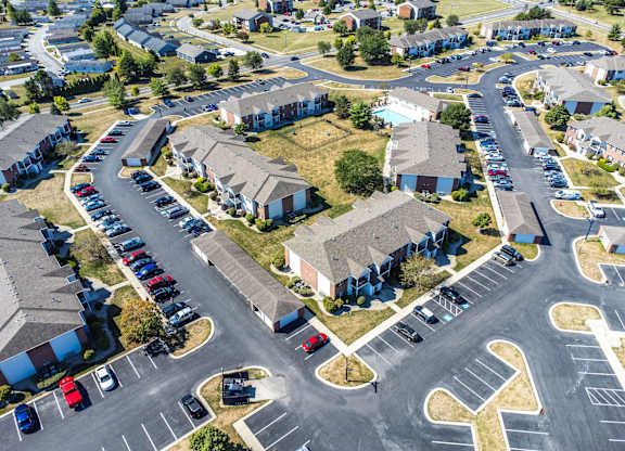 A parking lot with cars and apartment buildings in the background.