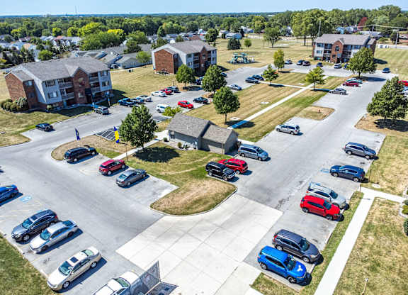A parking lot with cars and apartment buildings in the background.