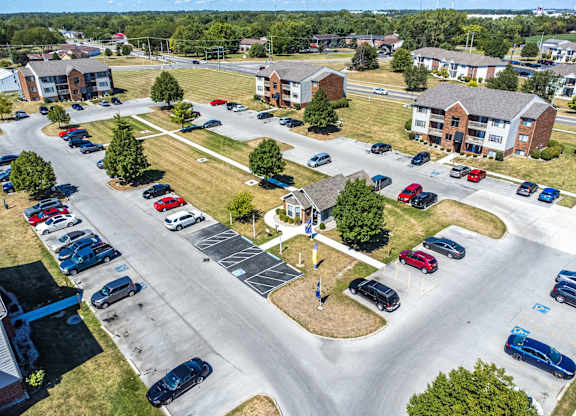A parking lot with cars and a small building in the background.