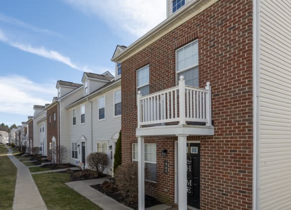 a row of brick apartments with a balcony and a sidewalk at Traditions at Slate Ridge, Reynoldsburg, OH 43068