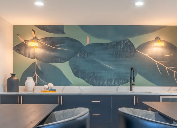 a kitchen with blue cabinets and a painting on the wall