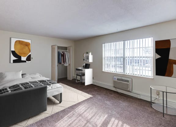 a bedroom with a bed and a desk in a room