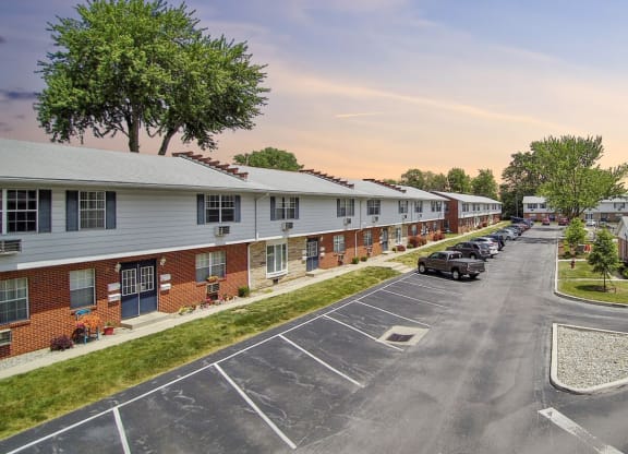 an empty parking lot in front of a row of apartment buildings