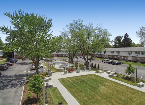 an aerial view of a parking lot with trees and buildings