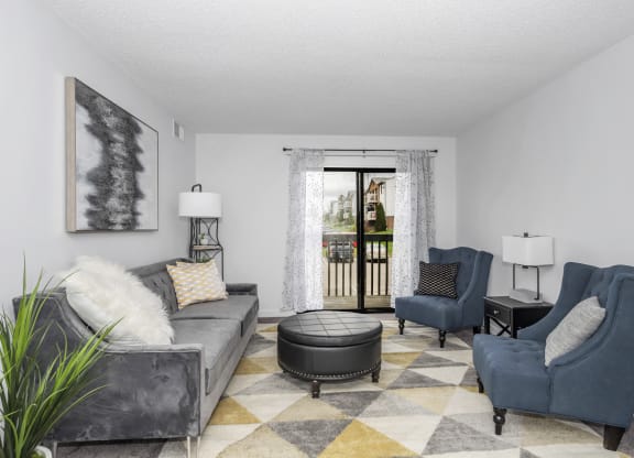 Living room with couches and chairs and a door to a balcony at Tall Timber Apartments, Cincinnati, OH, 45241