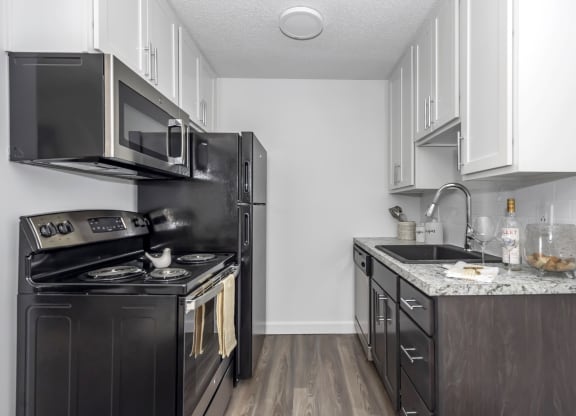Kitchen with black appliances and white cabinets and a black refrigerator at Tall Timber Apartments, Cincinnati
