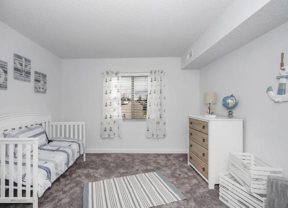 Nursery with a crib and a dresser and a window at Tall Timber Apartments, Cincinnati, Ohio