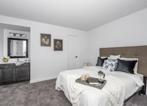 Bedroom with a king sized bed and a bathroom at Tall Timber Apartments, Cincinnati, OH