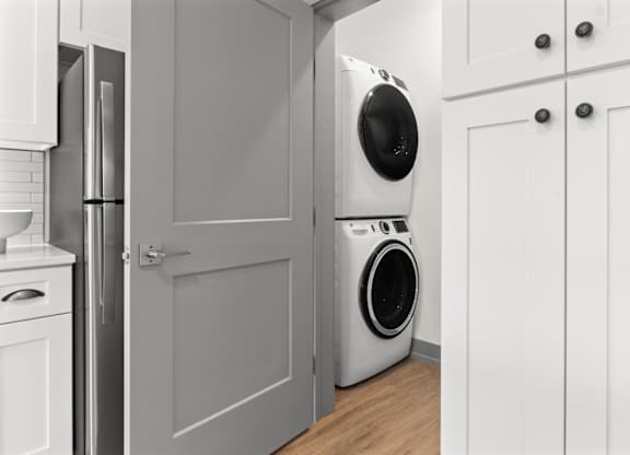 A white washing machine is in a kitchen.