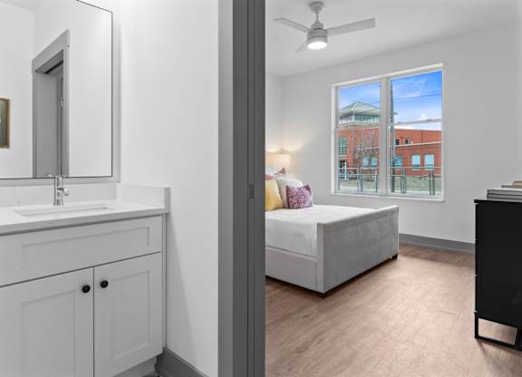 A bathroom with a white sink and a large mirror.