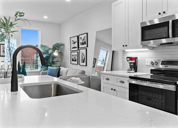 A modern kitchen with a large island and stainless steel appliances.