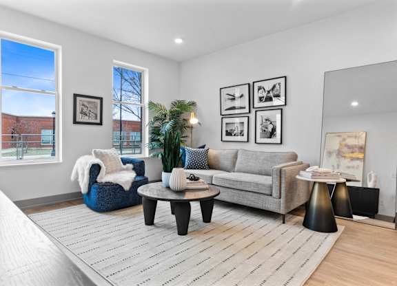 A living room with a grey couch, a blue chair, and a coffee table.
