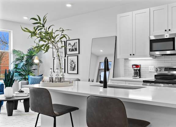 A modern kitchen with white cabinets and a large island.