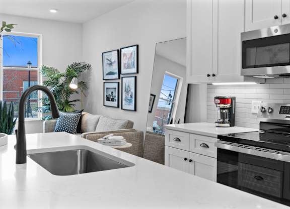 A modern kitchen with a stainless steel oven and microwave.