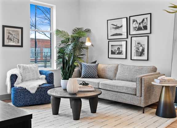 A living room with a grey couch, a blue armchair, and a coffee table.