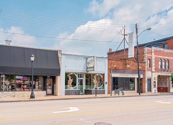 A street view of a small town with a variety of shops. at The Ridge Apartments, Ohio, 45213