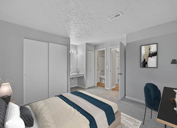A bedroom with a bed, chair, and a painting on the wall at The Reserve at Grand Valley Apartments, Ohio, 45150