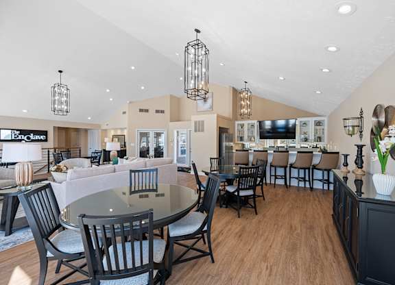 A modern dining room with a glass table and chairs at Enclave, 45431