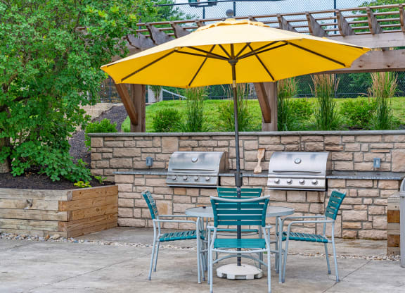 a patio with a table and chairs under an umbrella at Enclave, Beavercreek, 45431