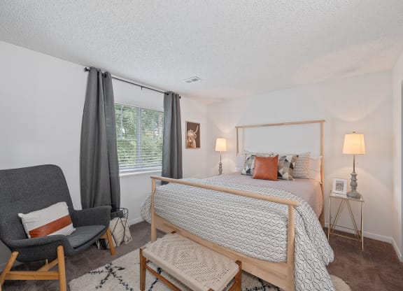 Bedroom with a bed and a chair  at Timber Glen Apartments, Batavia