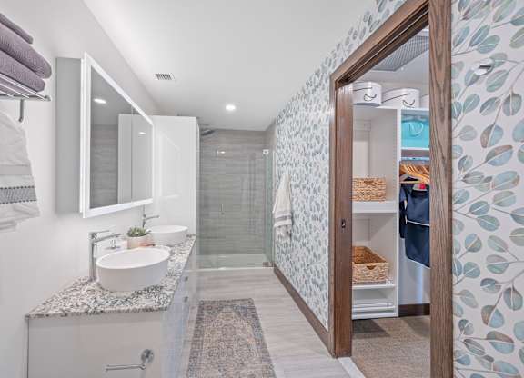 A bathroom with a sink, mirror, and shower at Sky Central Apartments, Ohio