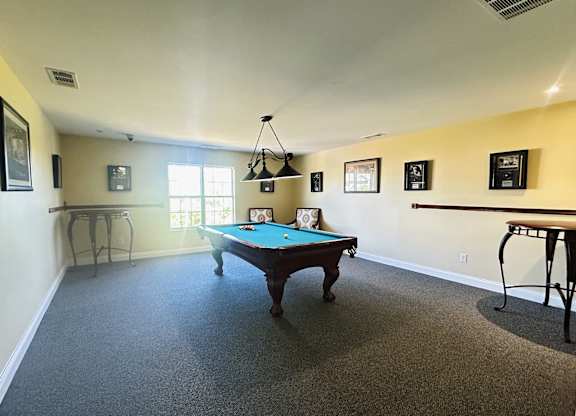 A pool table is in the middle of the room.