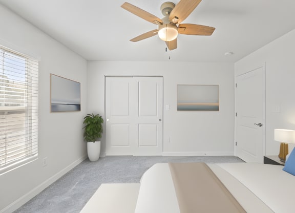 a white bedroom with a white bed and a ceiling fan