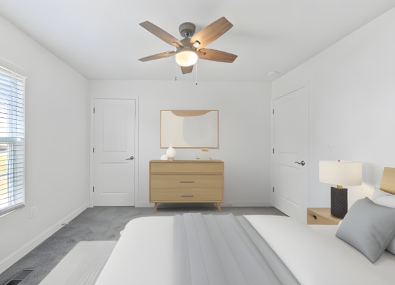 a white bedroom with a bed and a ceiling fan