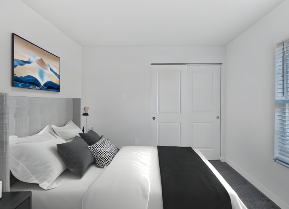 a bedroom with a large white bed and black and white pillows