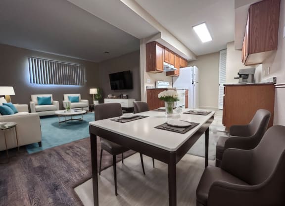 a living room and kitchen with a table and chairs