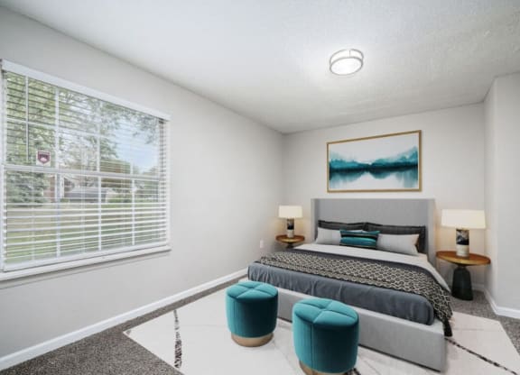 a bedroom with a bed and a large window at The Berryessa Apartments, Columbus, Ohio