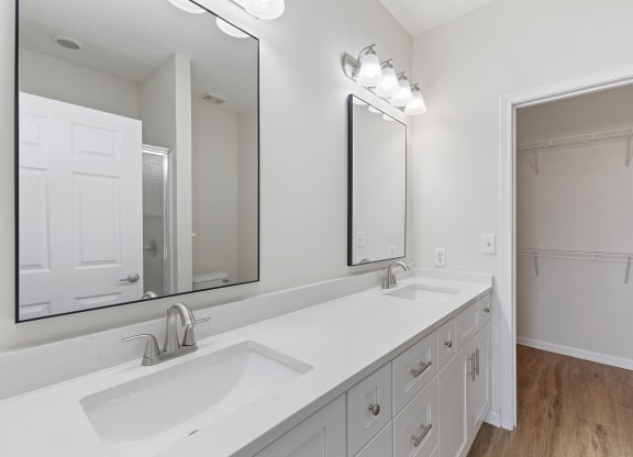 a white bathroom with two sinks and a large mirror at Four Bridges, Liberty Township