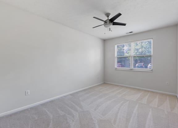 an empty living room with a ceiling fan and a window at Four Bridges, Liberty Township, Ohio
