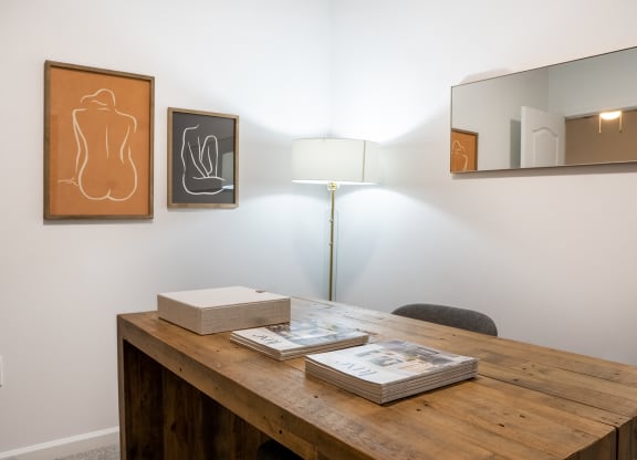 a desk with books and a lamp in a room with paintings on the wall  at Waterstone Landing, Ohio, 43551