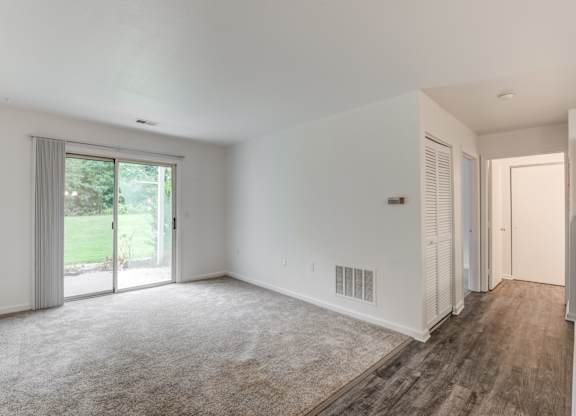 a living room with white walls and a sliding glass door