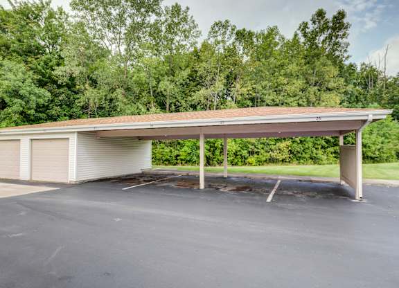 the covered parking lot has a white garage with a roof