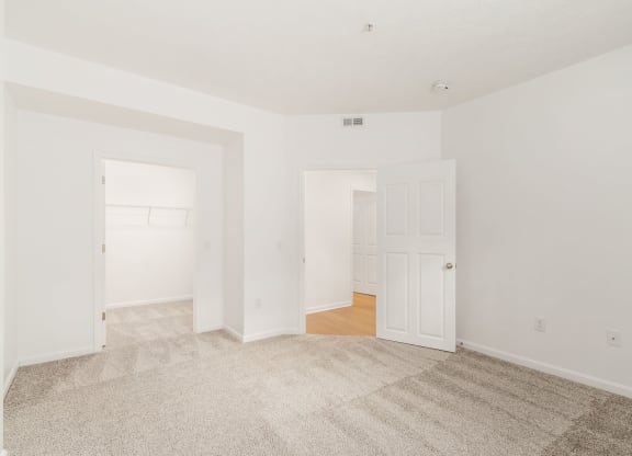 an empty living room with white walls and a carpet