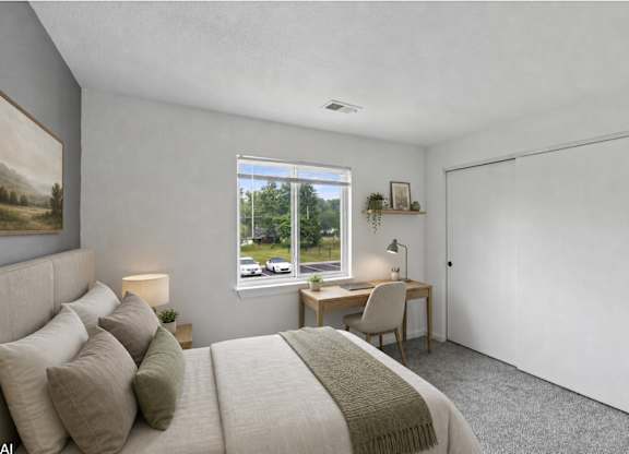 A bedroom with a large bed and a desk with a chair.