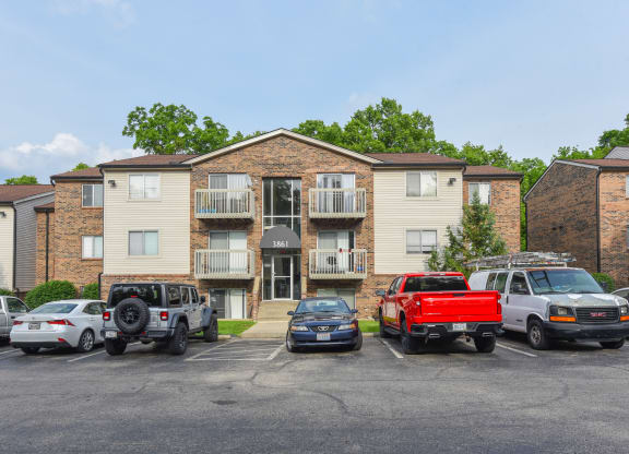 an apartment building with cars parked in front of it at The Woodridge Collection, Ohio