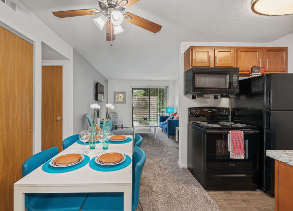 a kitchen and living room with a white table and blue chairs at The Woodridge Collection, Ohio, 45014