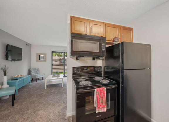 a kitchen with a stove microwave and refrigerator at The Woodridge Collection, Fairfield, OH