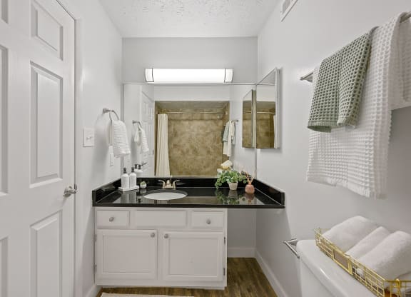 White bathroom with a black counter top and a mirror at Wrights Point, 41011