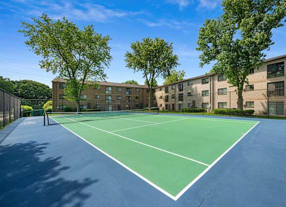 A tennis court is surrounded by apartment buildings at Rose Hill Apartments, Virginia, 22310