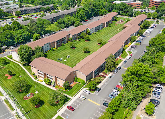 an aerial view of a building with a green lawn and a parking lot at Gainsborough Court Apartments, Fairfax, VA