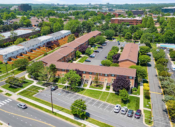 an aerial view of the campus with cars on the road and buildings at Gainsborough Court Apartments, Virginia