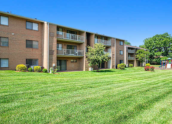 a view of an apartment complex with green grass in front of it at Gainsborough Court Apartments, Fairfax, 22030