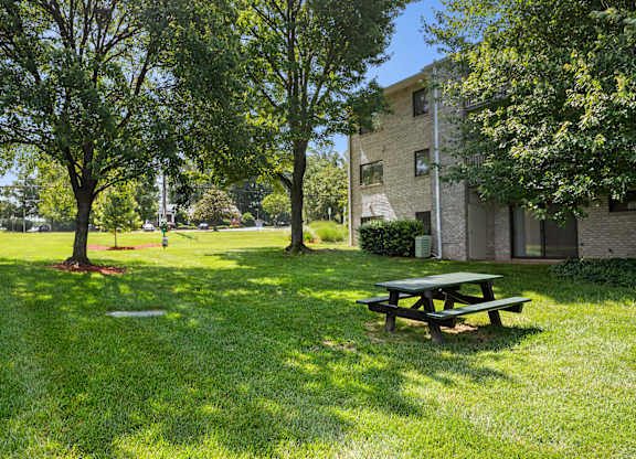 a picnic table in the grass in front of a building at Gainsborough Court Apartments, Fairfax