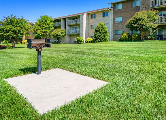 a mailbox on a pole in the middle of a grass field at Gainsborough Court Apartments, Fairfax, VA, 22030